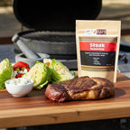 Spice n Easy Steak seasoning pouch beside cooked steak with salad and garnish